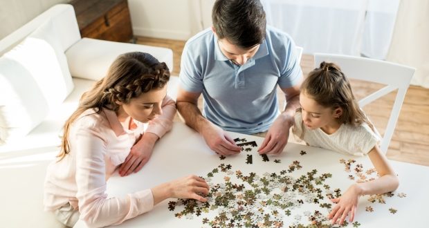Things to do with your child over the weekend-a family playing a puzzle game