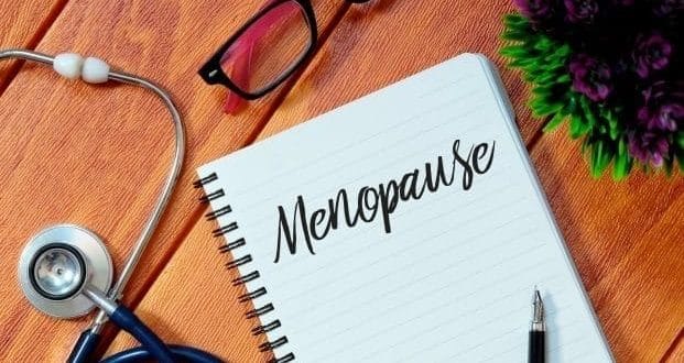 menopause symptoms nobody tells you about- menopause text written on a notepad