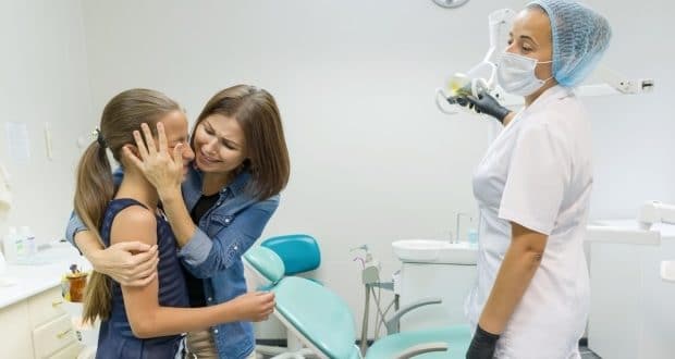 what not to do at the pediatric dentist's office-a mom consoling her daughter during a dental check up