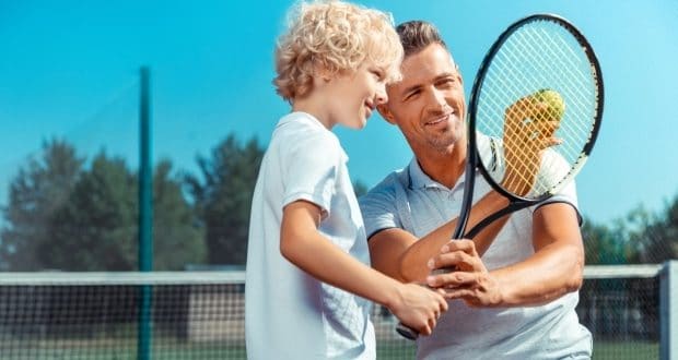 Sports for father and son bonding-dad teaching his son how to play tennis
