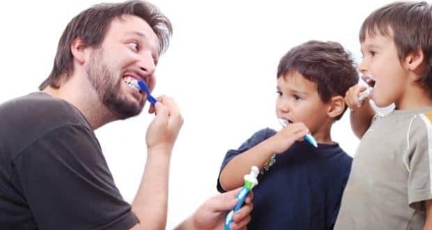 pediatric oral health and hygiene-dad teaching sons how to brush