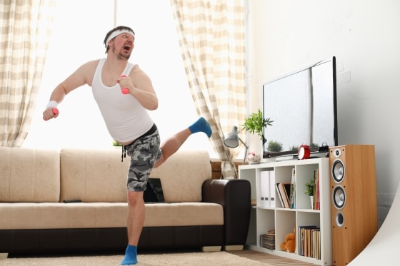 man working out at home with dumbbells