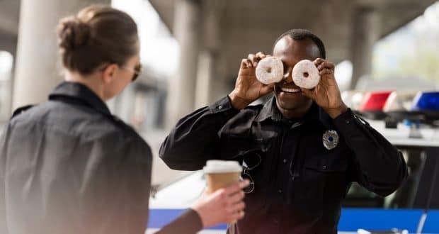 Police office amusing partner with donuts