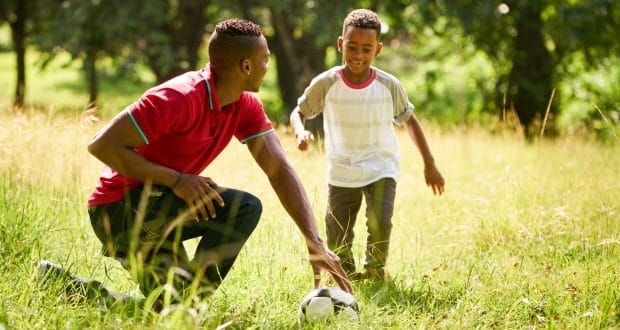 outdoor activities for a dad and son-dad and son playing ball on a field
