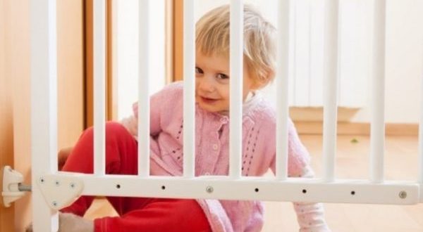 A guide for choosing the best baby safety gate- A baby behind a safety gate