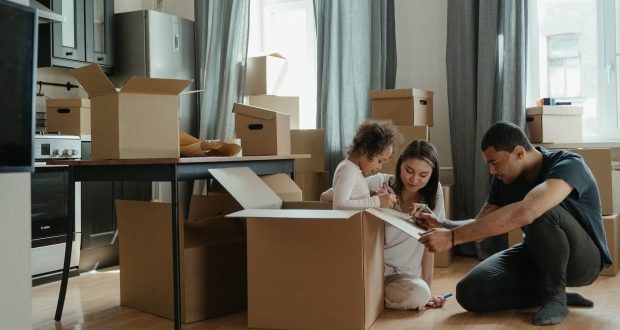 Tips for moving your family with ease- A family filling up boxes
