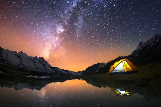 Camping in the mountains under the starry night sky.