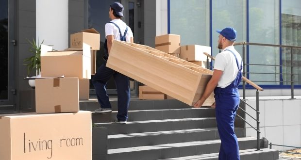 Tips for making your cross-country move easier- men moving boxes into a house