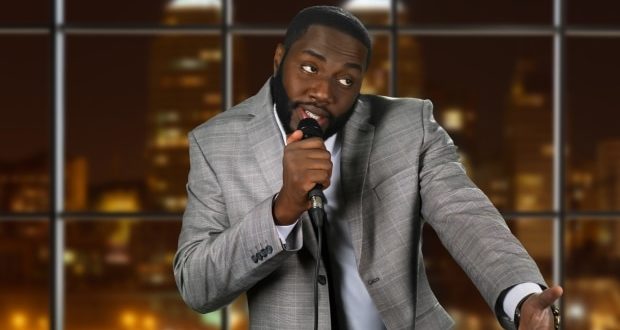 Black stand-up comedian on night background