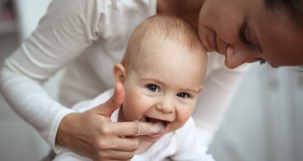 Understanding the stages of teething in babies-Mom with teething baby