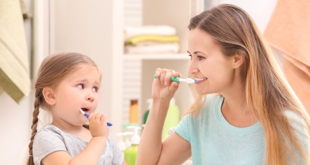 How to help your kids brush and floss- Mom helping kid brush