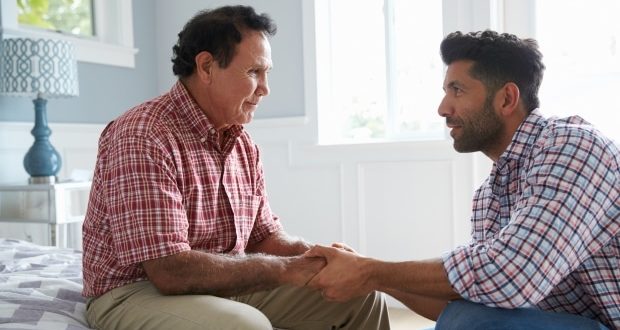 How to help a parent suffering from cognitive decline- A son holding his dad's hands