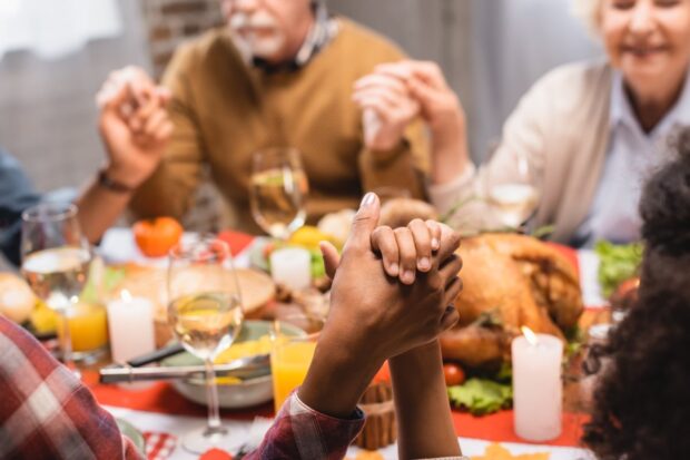 Family praying before Thanksgiving dinner
