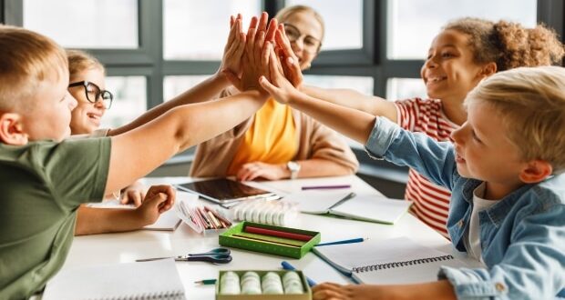 Value kids can learn from their teachers - A teacher giving her students a high five