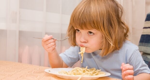 How to teach your child to eat nutritious meals- a little boy enjoying a plate of pasta