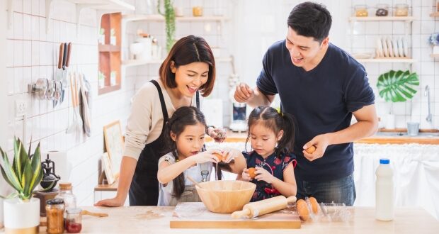 How To Teach Your Kids Valuable Cooking Skills - Couple cooking with their kids