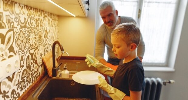 Child Friendly Chores To Introduce To Your Child- A boy doing the dishes