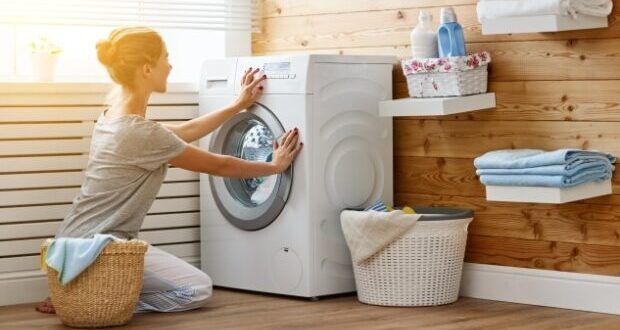 Tips for maintaining your washing machine- A lady loading a washing machine