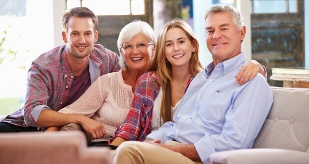 Transitioning To Parenting Your Adult Child-Family With Adult Children Relaxing On Sofa At Home Together