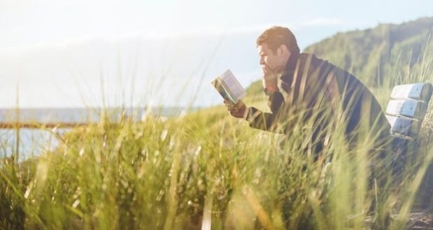 Stepdad selfcare- Stepdad reading book along the lake shore