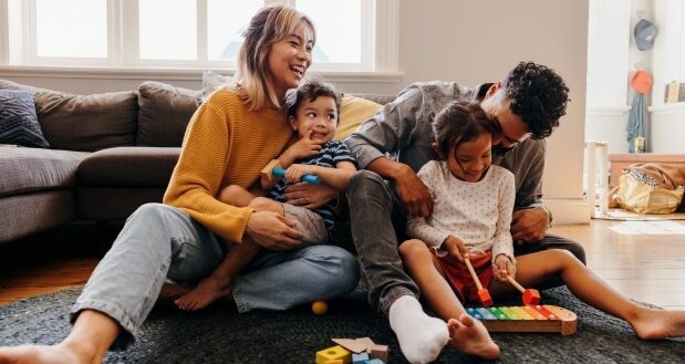 A Guide To Positive Transformation For Parents - A happy family relaxing in their lounge