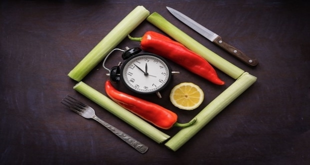 Intermittent Fasting For Beginners- long peppers and a small clock.