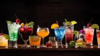Various tasty cocktails displayed on a dark table in a bar.