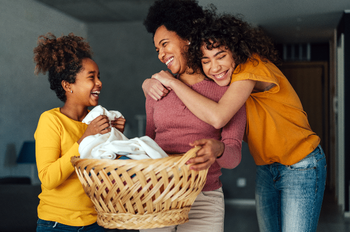 Balancing Household Responsibilities In A Blended Family-Teen girls doing laundry with their mom