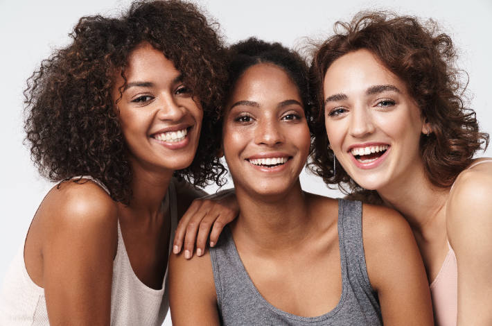 Women's Equality Day- Three women smiling into the camera.