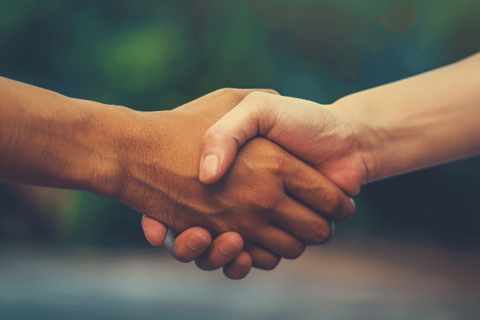 Hands of two dads clasped in a supportive handshake,