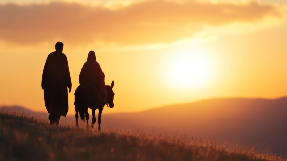 Mary and Joseph traveling to Bethlehem with a donkey under a golden sunset, symbolic of the journey to Jesus' birth 