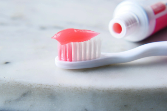 toothbrush with toothpaste on a white surface