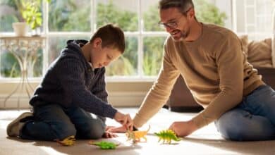 bonding with stepchildren -Stepdad and stepkid, playing with toys at house for plastic dinosaur