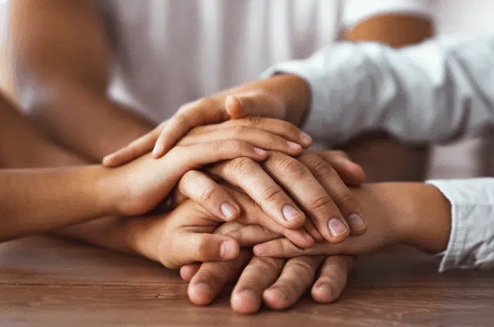 Places To Find Support As A Blended Family - multiple hands resting on each other symbolizing care, support and unity