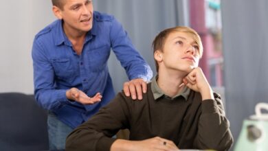 Why Do Kids Hate Their Stepparents-Young unhappy teenage boy ignoring his stepdad, man trying conversate with boy.