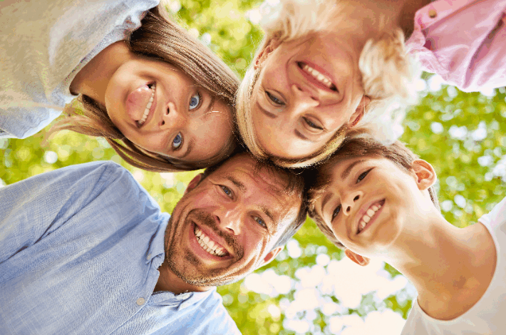 What Do You Teach Your Children By The Way You Treat Their Mother? A happy family smiling into the camera