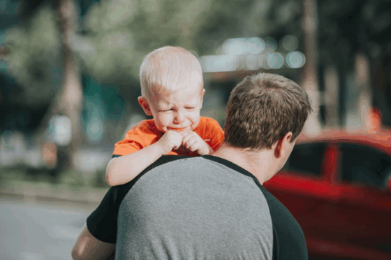 Stepdad holding and comforting stepson