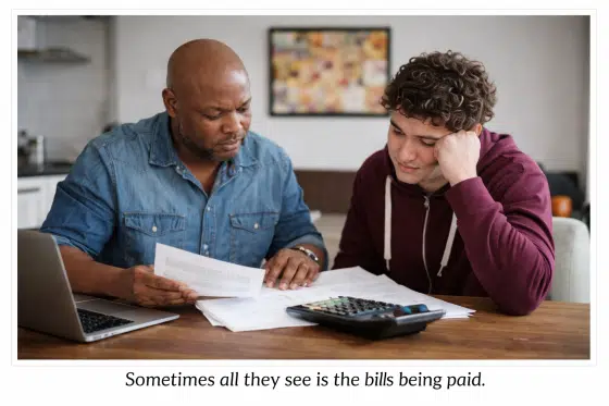Stepdad paying bills with stepson watching
