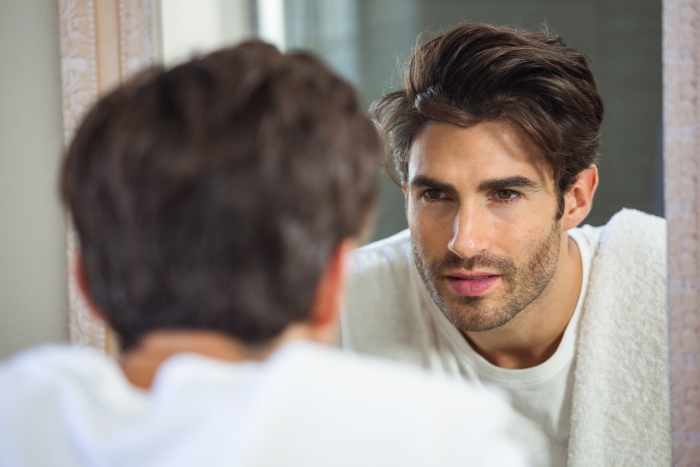 Man looking at reflection in the mirror