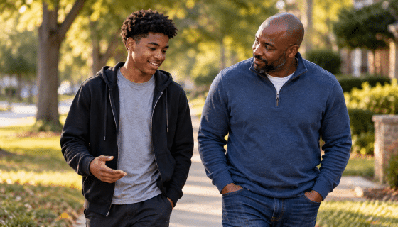 Stepdad building trust with his teenage stepson during a relaxed walk and conversation.