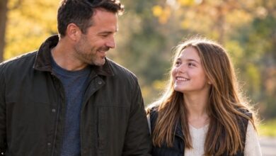 Successful stepdad - Stepdad and teenage stepdaughter smiling at each other during a walk, reflecting the trusting relationship they've developed.